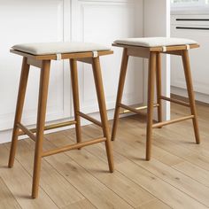 two wooden stools sitting next to each other in a kitchen