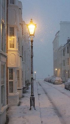 a street light in the middle of a snowy city