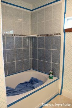 a bathtub with blue and white tile on the walls