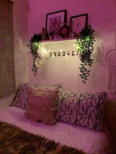 a bed that has some plants on the headboard and lights in the wall above it