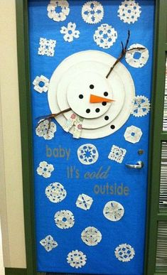 a snowman made out of paper plates on top of a blue and green door