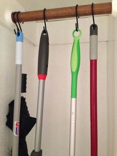 three different colored umbrellas hanging from a rack in a closet, one is green and the other is red