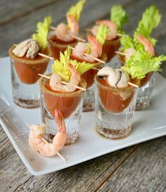 small glasses filled with shrimp and garnish on a white plate