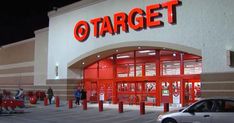 a target store at night with people walking in the front door and cars parked outside