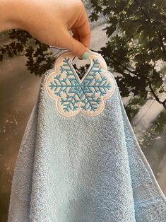 someone is holding a blue towel with a snowflake design on it and hanging from the side