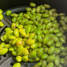 some green olives are being cooked in a pot