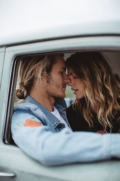 a man and woman sitting in the back seat of a car looking into each other's eyes