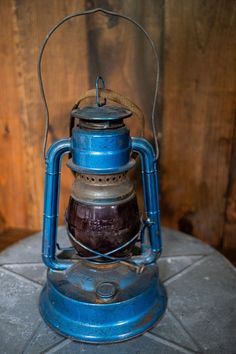 an old blue lantern sitting on top of a table