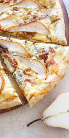 an apple and cheese pizza on a cutting board with slices cut out to show the toppings