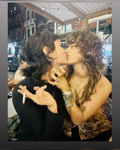 two women kissing each other while sitting down