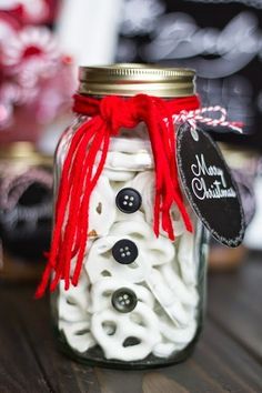 a mason jar filled with buttons and string on top of a wooden table next to other items