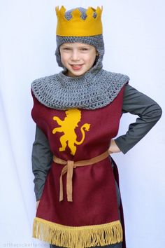 a young boy wearing a knight costume with a crown on his head and a chain around his neck