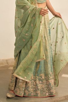 Turquoise lehenga with zardozi embroidered floral motifs. Comes with matching blouse and gota lace embellished dupatta. - Aza Fashions Unstitched Raw Silk Lehenga With Gota Work, Unstitched Lehenga With Resham Embroidery In Chanderi, Eid Chanderi Lehenga With Zari Work, Pista Green Lehenga With Resham Embroidery In Organza, Pista Green Organza Lehenga With Resham Embroidery, Silk Lehenga With Zari Work For Eid, Eid Silk Lehenga With Zari Work, Designer Raw Silk Lehenga With Gota Work, Designer Tissue Silk Lehenga With Zari Work