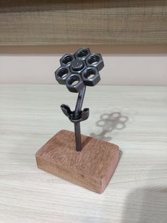 a small metal object on top of a wooden stand with holes in it's center