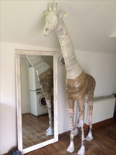 a giraffe is standing in front of a mirror