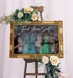 a wedding seating chart on a easel with flowers and greenery next to it