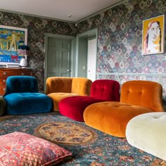 a living room filled with colorful chairs and rugs on top of a blue floor