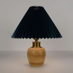 a lamp that is sitting on top of a table with a blue shade over it