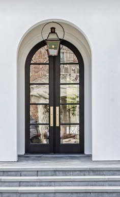 the front door to a building with two large doors and steps leading up to it