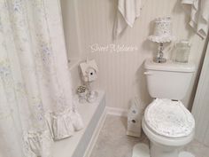 a white toilet sitting inside of a bathroom next to a bath tub and shower curtain