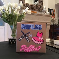 a cardboard box with stickers on it sitting on a table next to flowers and a mirror