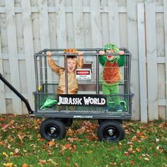 two children are in a toy cart with the words jurask world on it