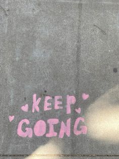 graffiti written on the side of a building says, keep'n going with pink spray paint