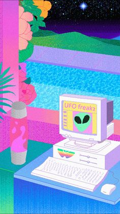 an alien computer sitting on top of a desk next to a vase filled with flowers