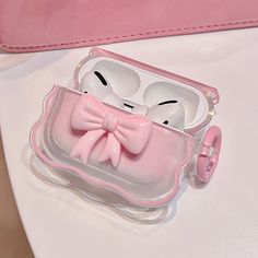 an earphone case with a pink bow on the front and two ears in the back