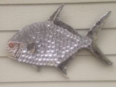 a metal fish on the side of a house