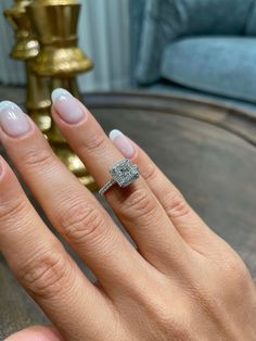 a close up of a person's hand with a diamond ring on their finger