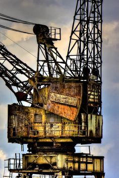 an old rusty crane sitting on top of a building