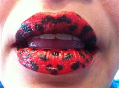 a woman's lips with black and red designs on them, including the tongue