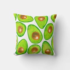 an avocado print pillow on a white background with orange and green accents,