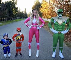 three people in costumes standing on the side of a road with one person wearing a costume