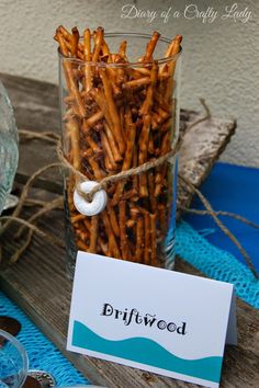 a jar filled with fries sitting on top of a wooden table next to a sign