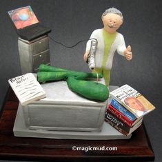 a statue of a man on top of a bed with books and a cell phone