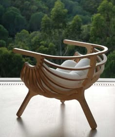 a wooden chair sitting on top of a hard wood floor next to a lush green forest