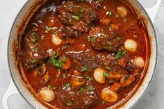 a pot filled with stew and potatoes on top of a table