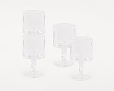 three clear wine glasses sitting next to each other