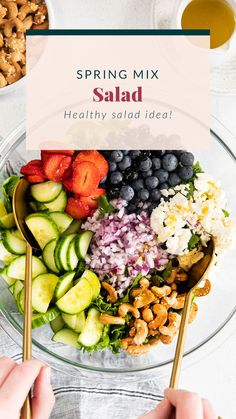 a salad with strawberries, cucumbers, blueberries and nuts in it