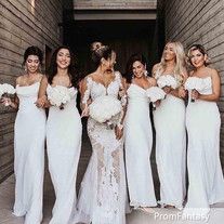 a group of women standing next to each other wearing white dresses and holding bouquets