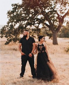 a man and woman standing next to each other in a field