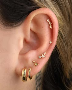 a woman wearing three different ear piercings on her left and right side of the ear