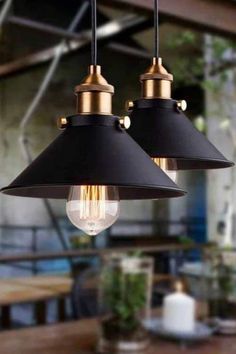 two black and gold pendant lights hanging from a ceiling