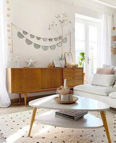 a living room with white couches and wooden coffee table in front of a window