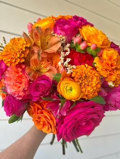 a woman holding a bouquet of colorful flowers