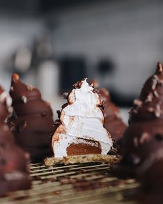 chocolate desserts with white frosting and sprinkles on a cooling rack