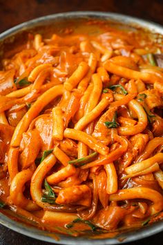 a bowl filled with pasta and sauce on top of a table