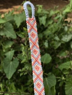 a close up of a rope with leaves in the back ground and bushes behind it